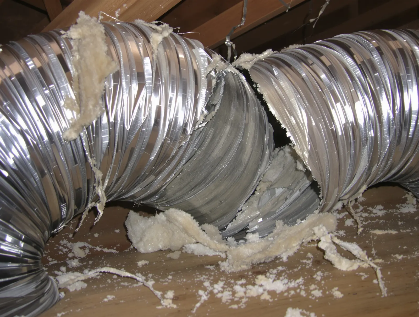 Disconnected ductwork in an attic with a visible gap where conditioned air escapes